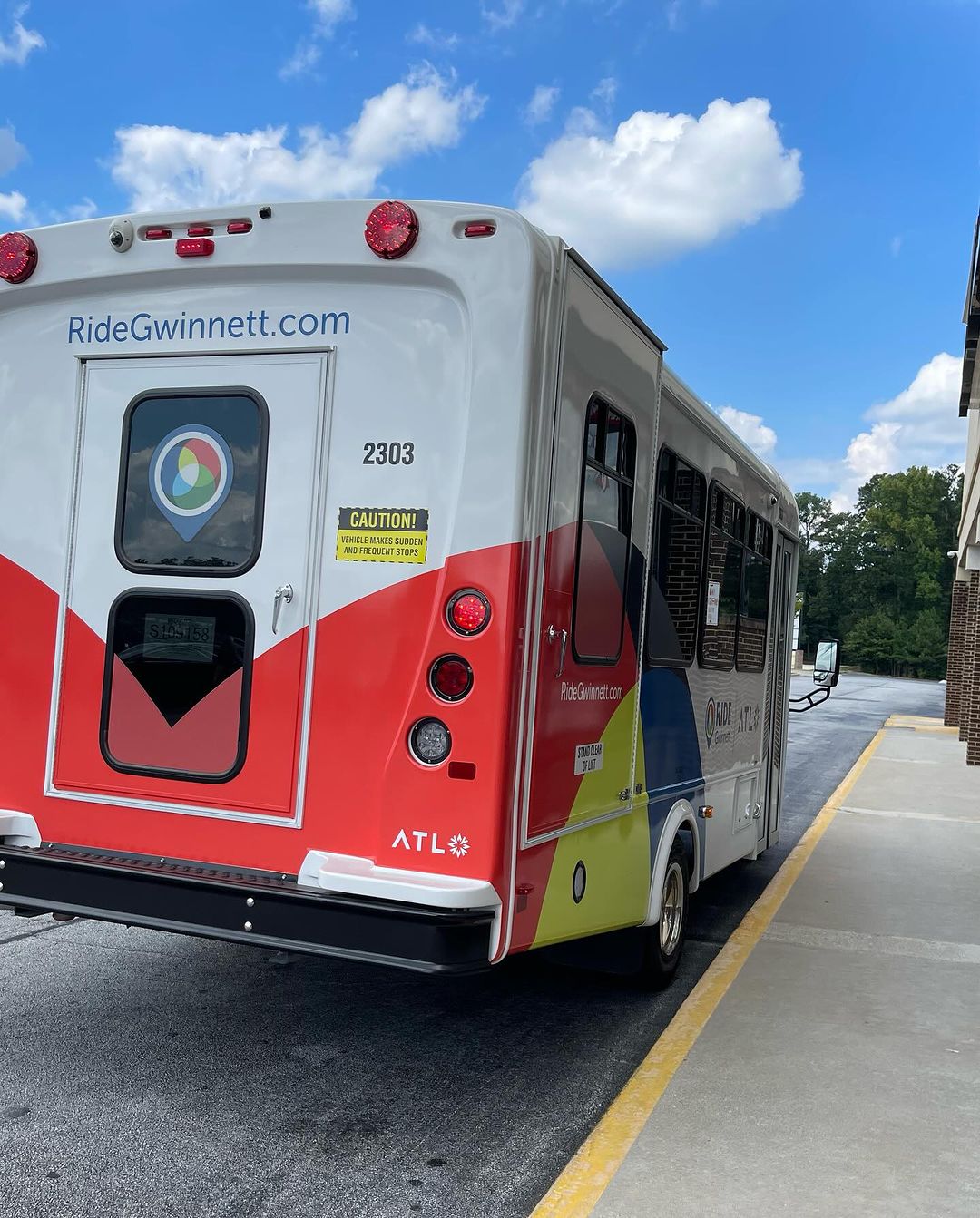 Gwinnett County's Ride Gwinnett transit service microtransit van pulls off after alighting passengers at a local store.