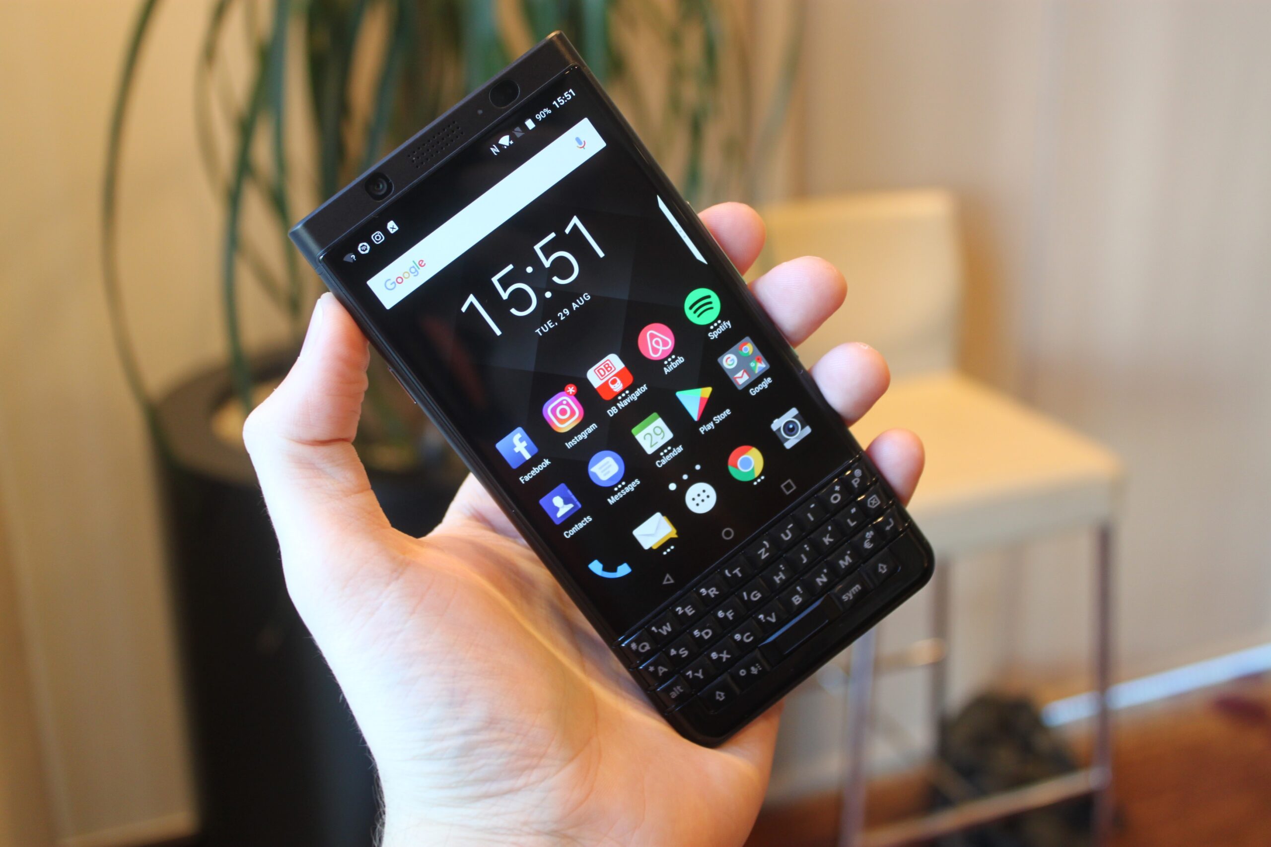 A Blackberry Keyone smartphone being held by a hand